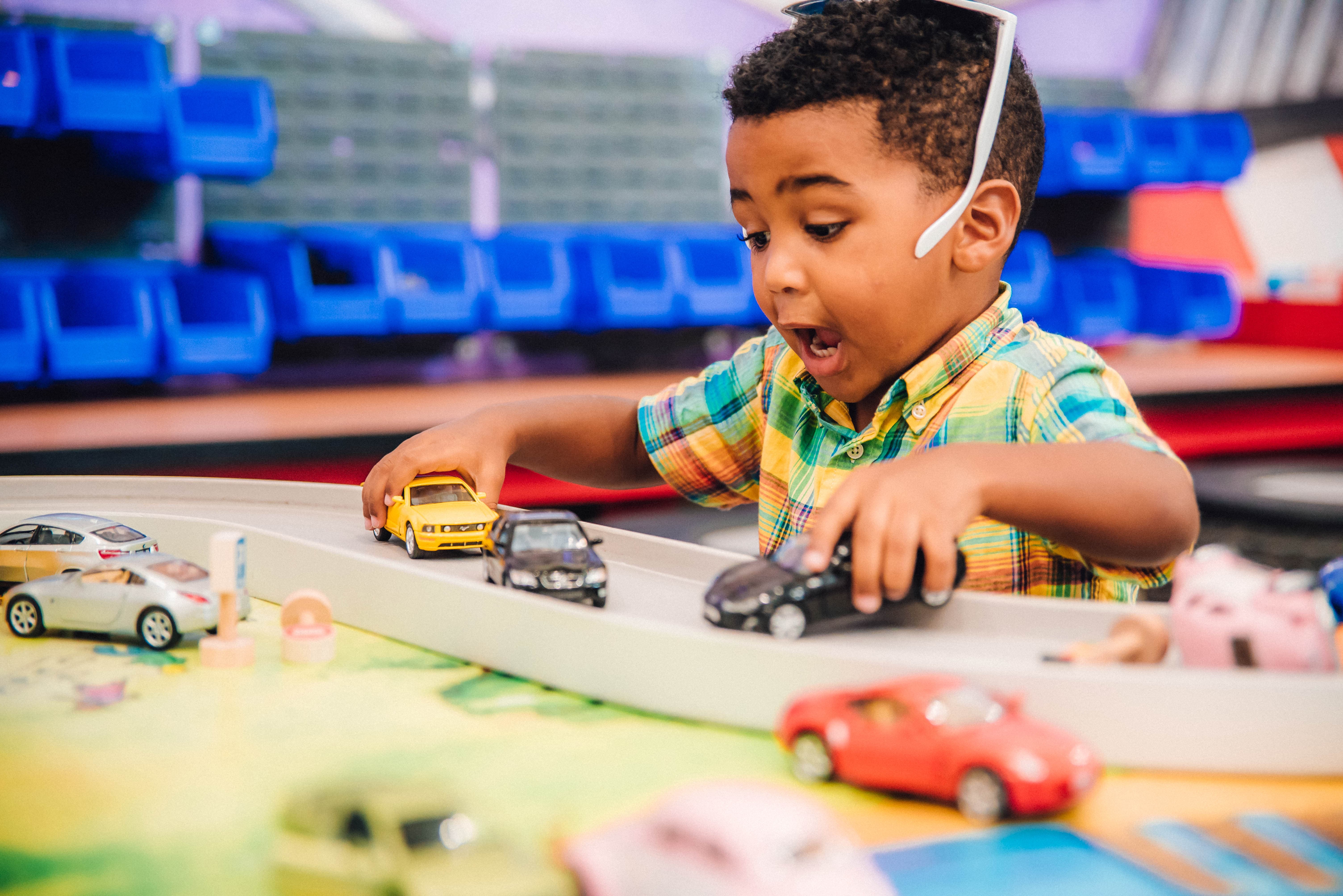 A young boy playing with toy cars