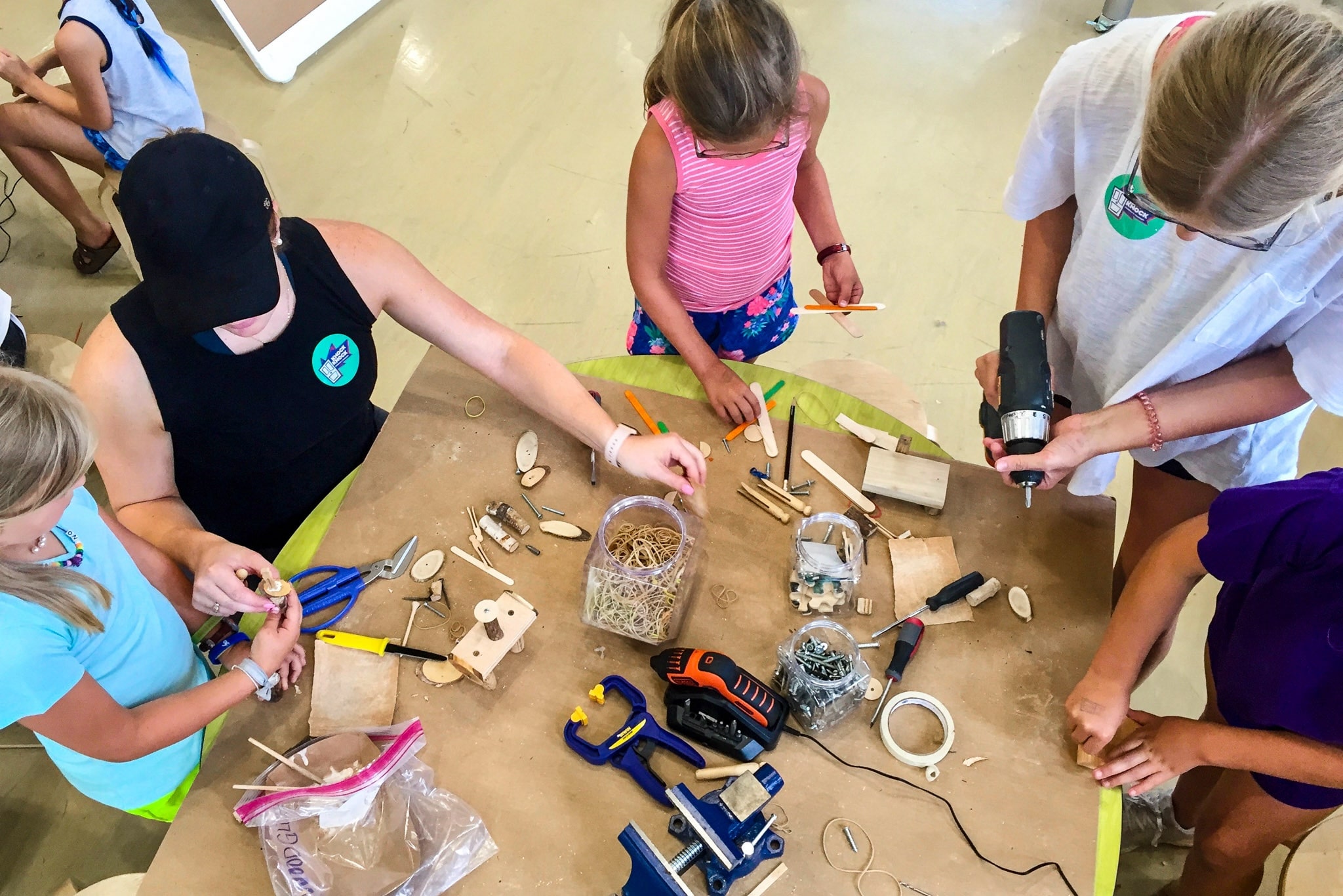 A group of children and adults using craft supplies to construct toys