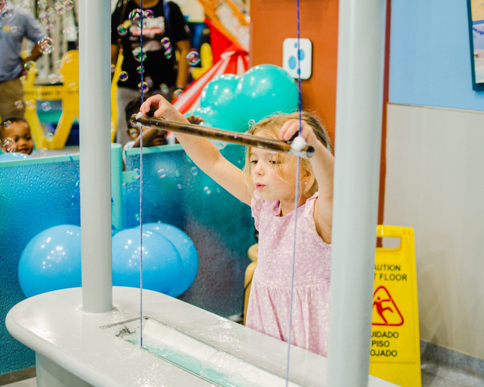 A little girl playing with the bubble machines