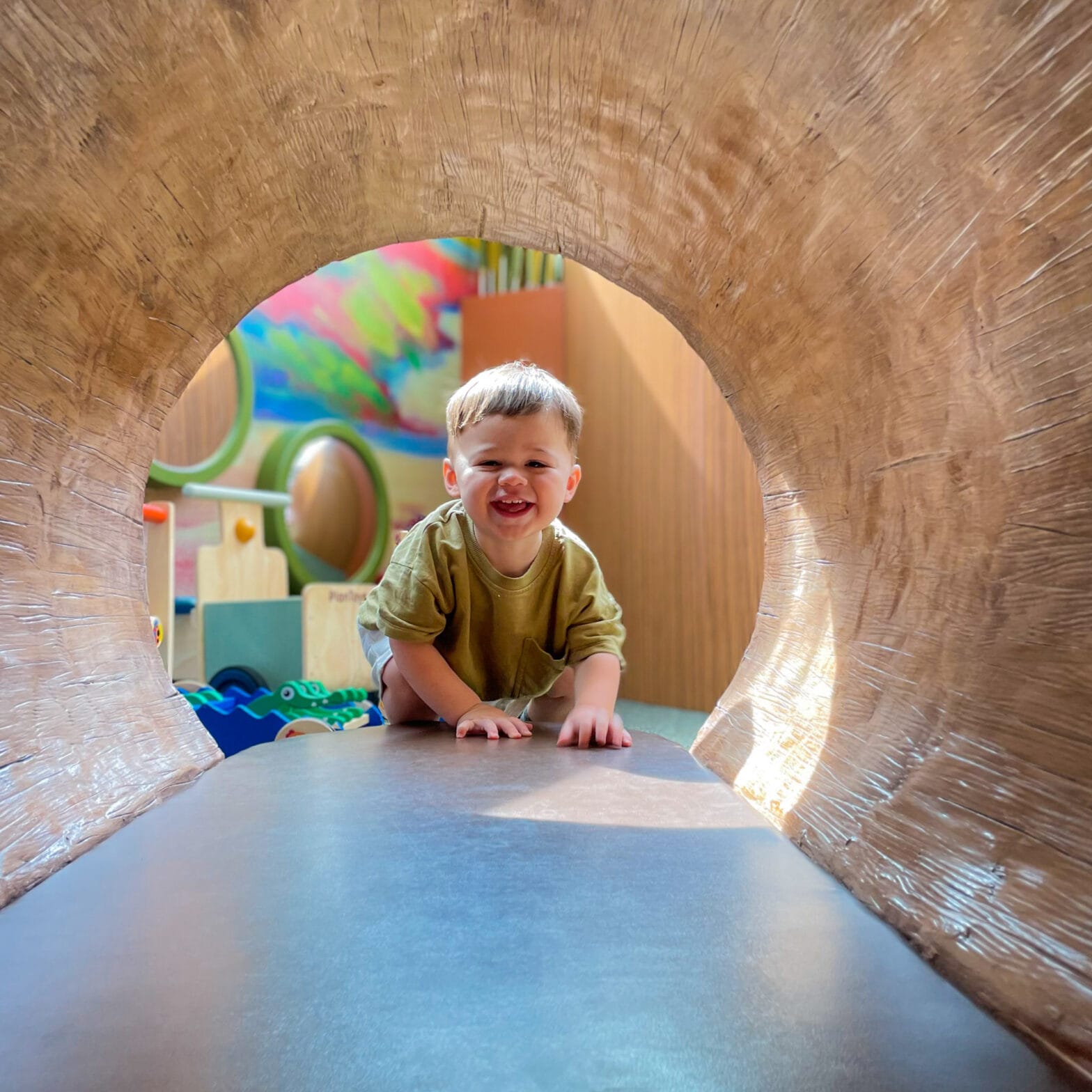 A little boy at the end of the tunnel in the Crawbaby play area.