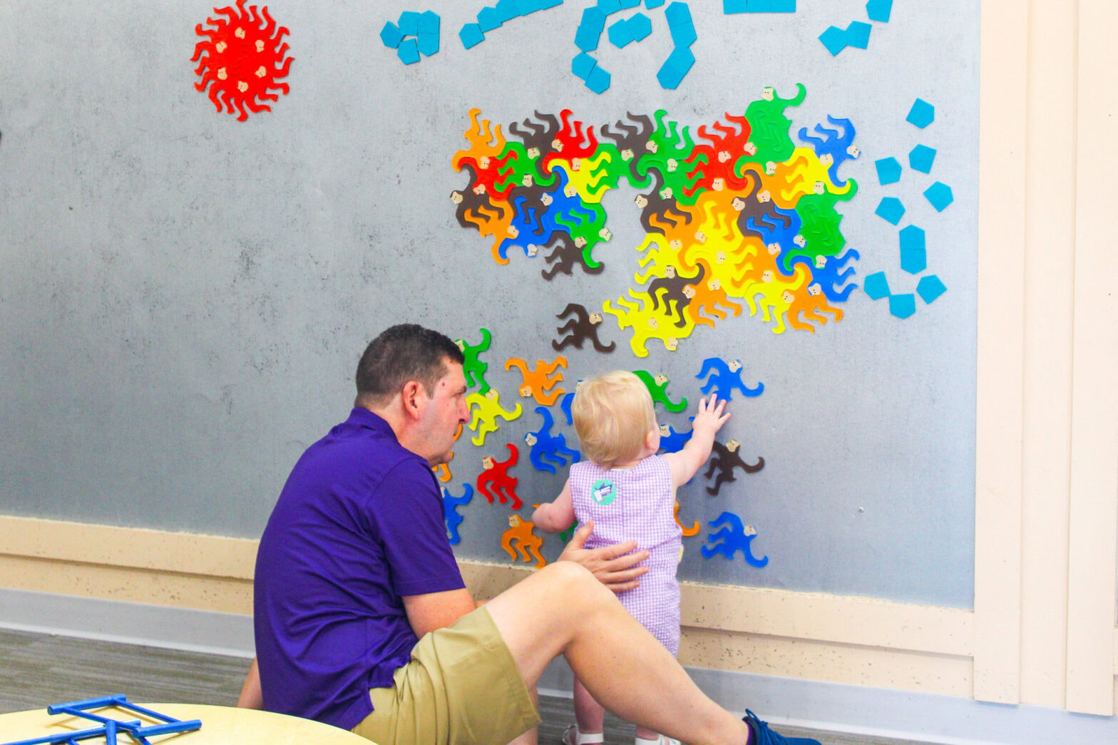 A father playing with his child at the magnet wall