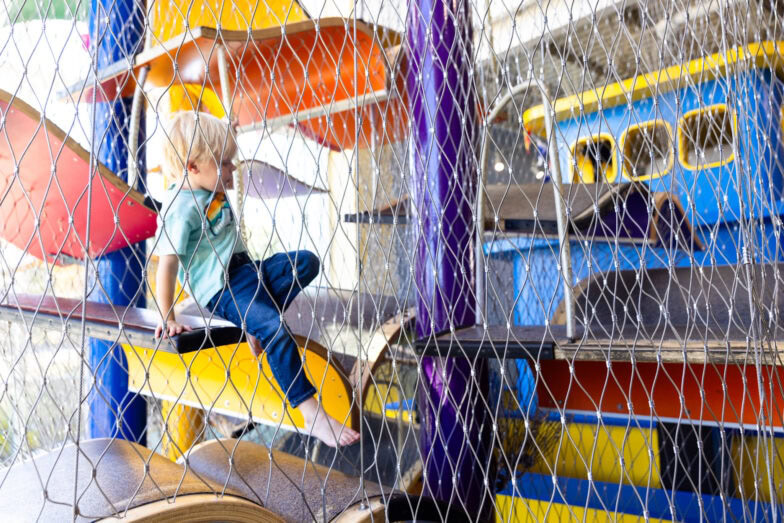 A little boy coming down the steps of the inside of the Storybook Climber