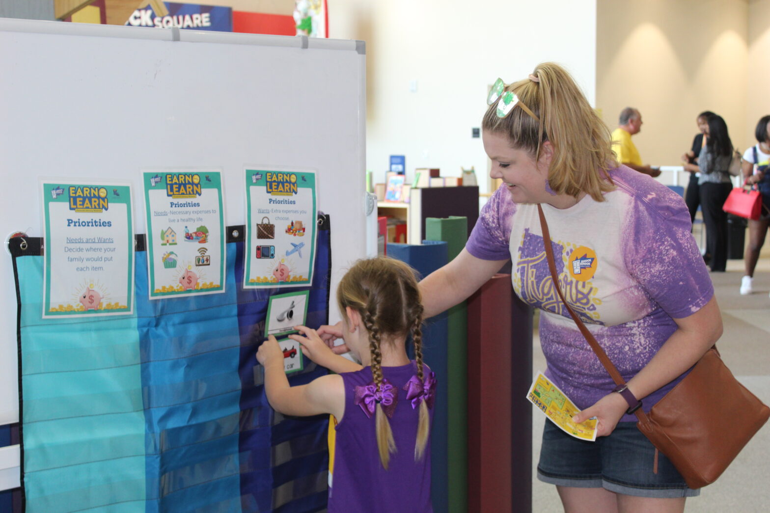 Mother and daughter sort items between needs and wants.