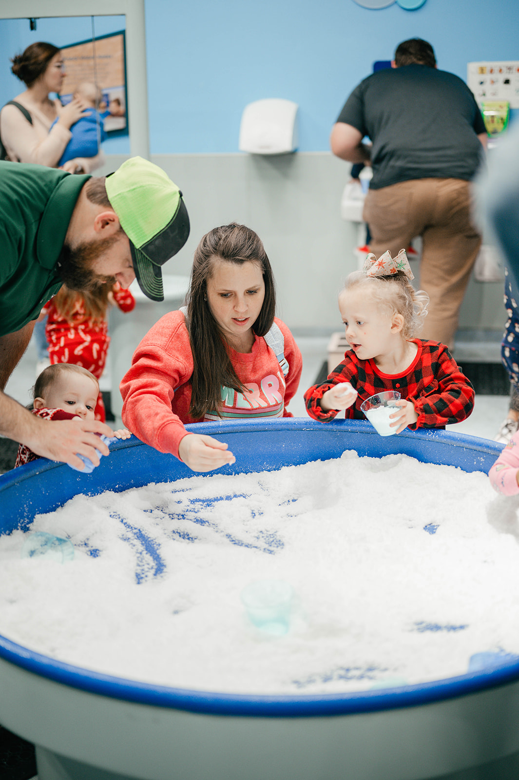 a family plays with fake snow in bubble playground
