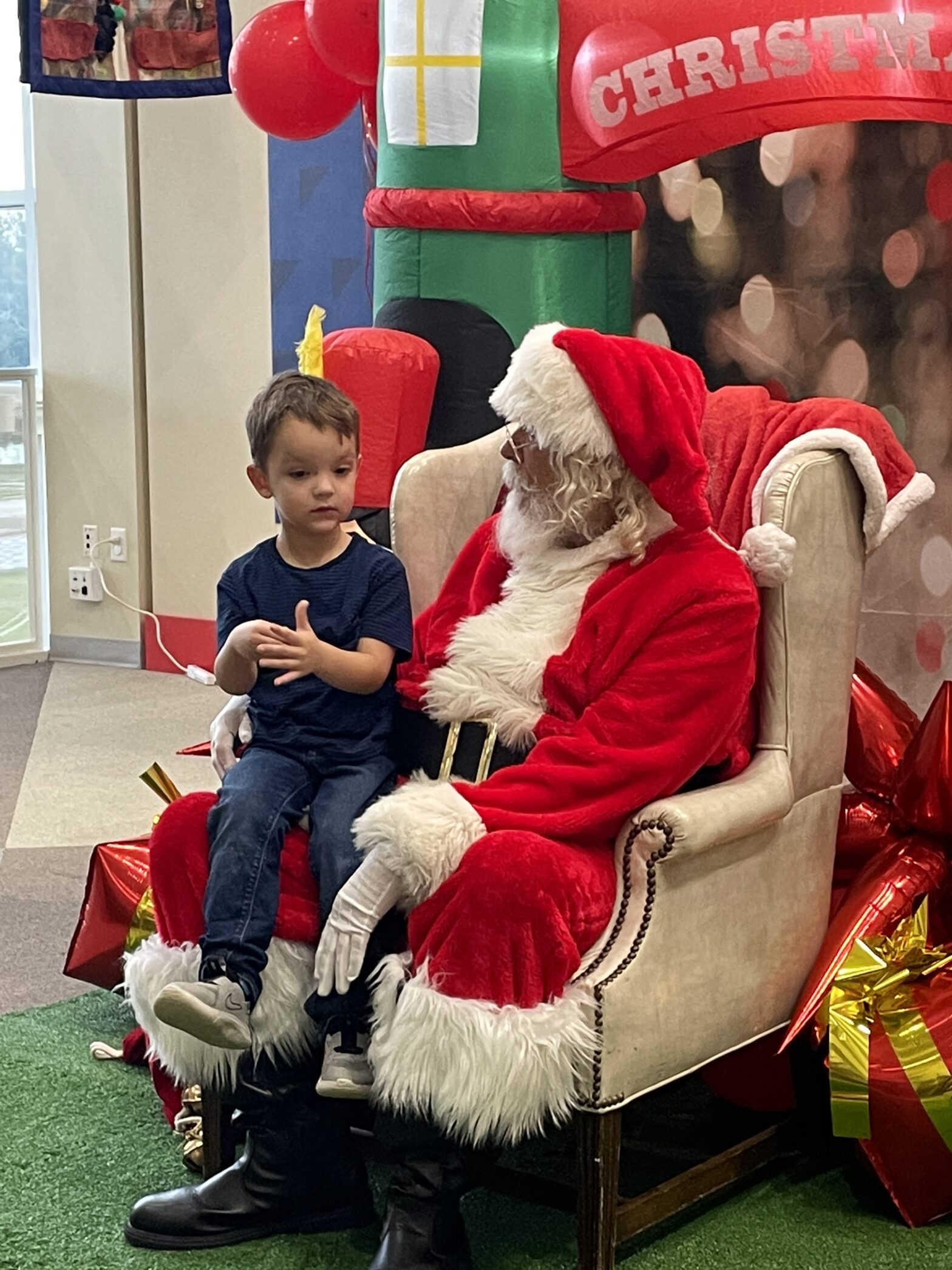 a boy sits on Santa's lap to take a picture
