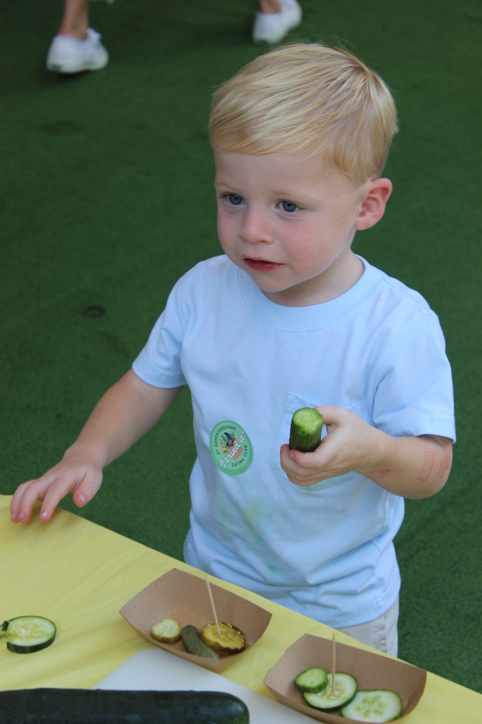 Little boy eats a cucumber