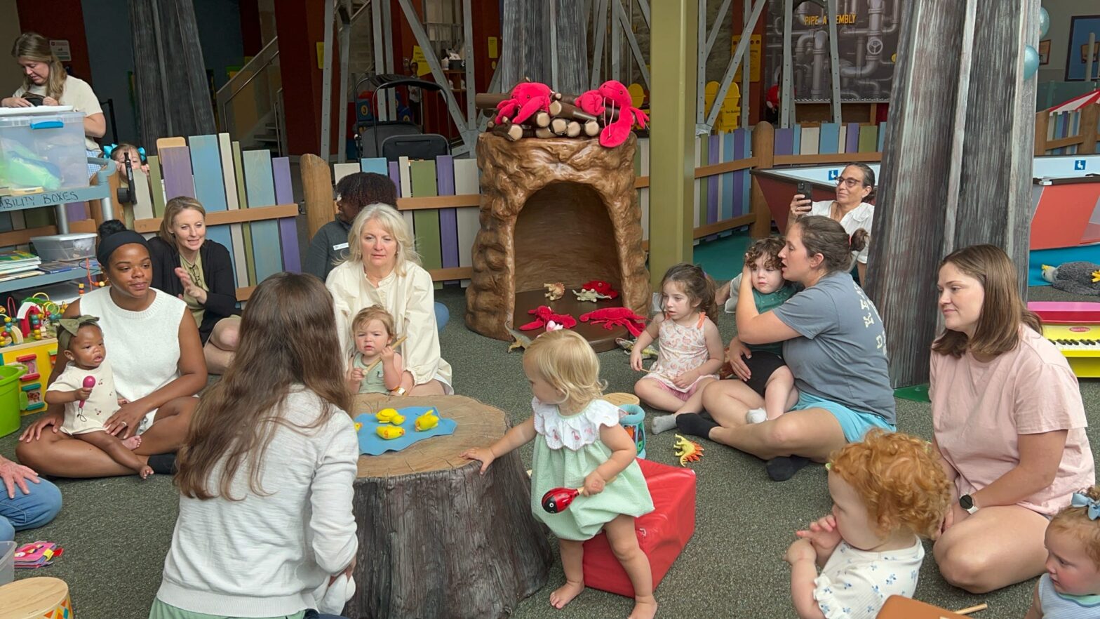 The crowd of caregivers and children gather in Crawbaby