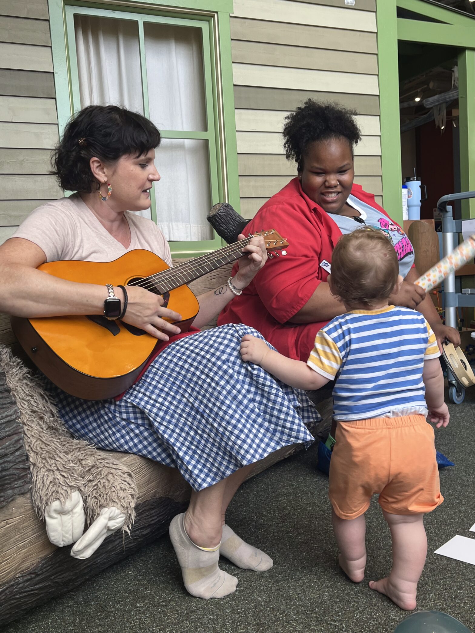 a toddler watches as our Baby Rhyme Time facilitators sing and play guitar