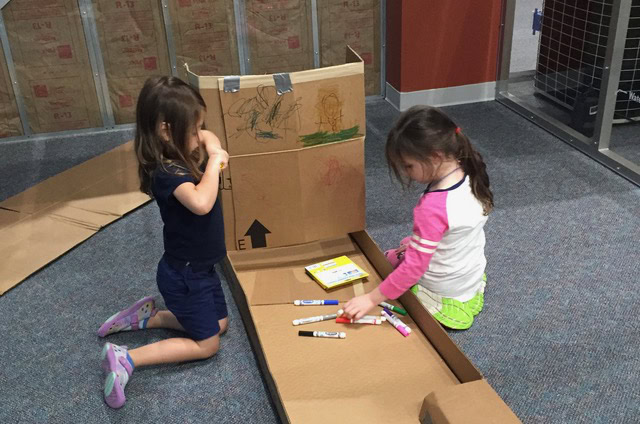 Children construct mini golf course using cardboard.