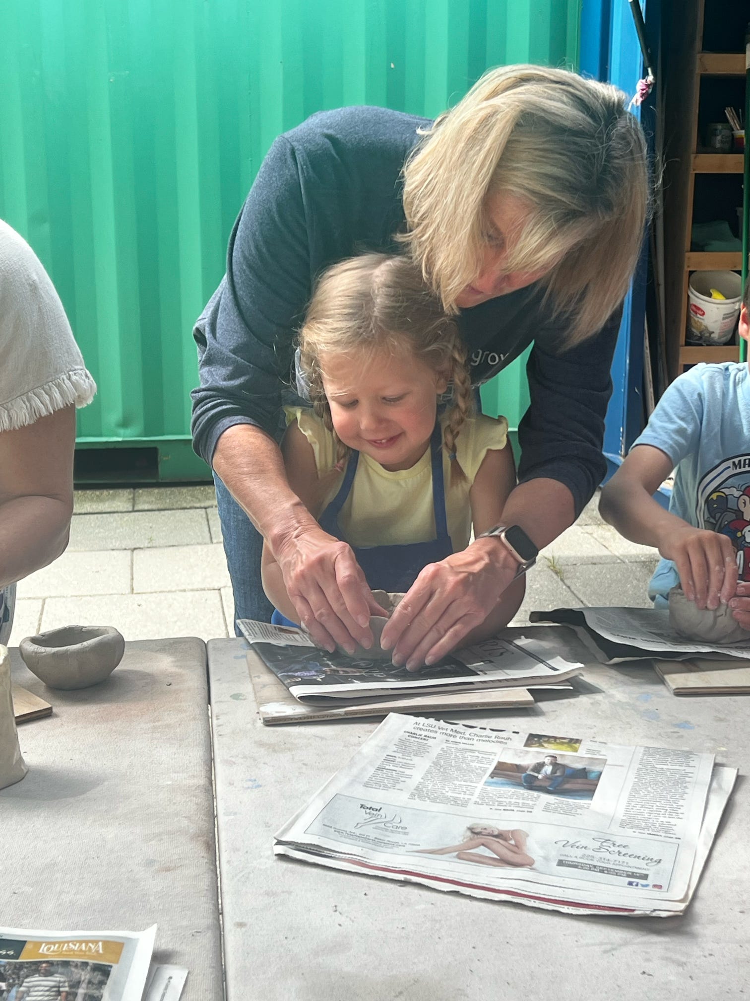 Child and grandmother mold clay.